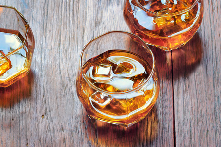 Glass with Whiskey on table rustic wooden background, top viewの写真素材