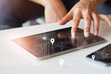 Businessman using tablet and smartphone with global network worldwide connection technology on virtual screenの写真素材