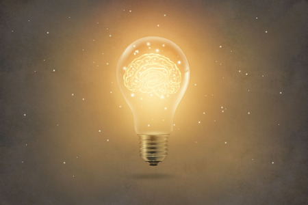 golden brain glowing inside of light bulb on paper texture background