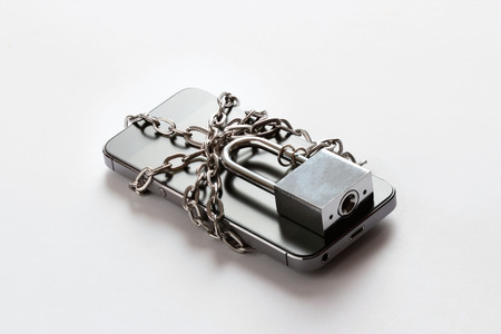 Smartphone with chain locked on white background, security and piracy network conceptの写真素材