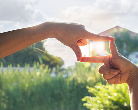 hands symbol with house in sunshine nature backgroundの写真素材