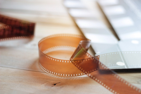 Movie clapper and film strip on a wooden backgroundの写真素材