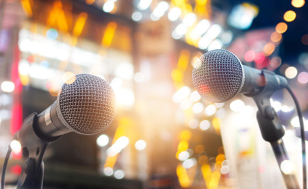 Microphones on stage in concert on lighting backgroundの写真素材