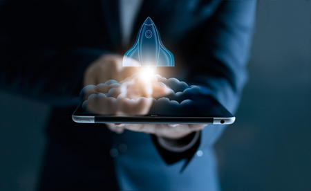 Startup concept, transparent rocket is launching and flying out of tablet on screenの写真素材