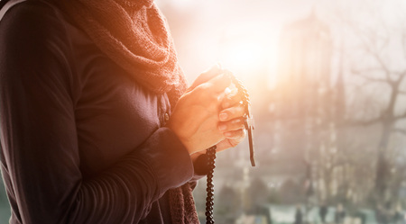 Christian Religion and hope concept. Woman hands praying with rosary and wooden cross. Bless god...