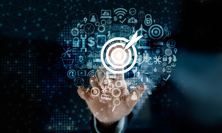 Digital marketing. Businessman touching darts aiming at the target center with icon network connection. Business goal and technology conceptの写真素材