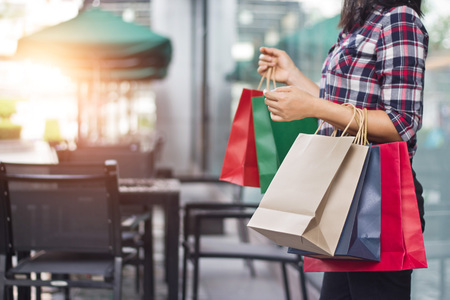 Woman holding shopping bags while standing on the mall background.の写真素材