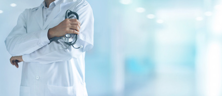 Medicine doctor with stethoscope in hand standing confidently on hospital background, healthcare concept.の写真素材