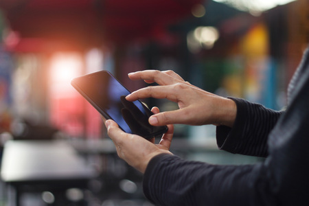 Human hands using mobile smartphone in coffee shop