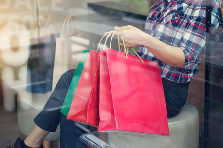 Woman with shoppingbags in hand relaxing in shop of department store, or cafe cornerの写真素材