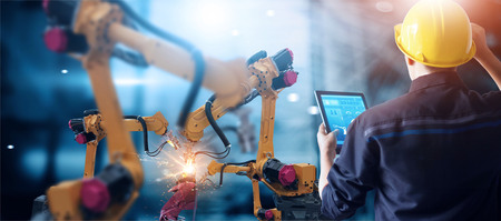 Engineer check and control welding robotics automatic arms machine in intelligent factory automotive...