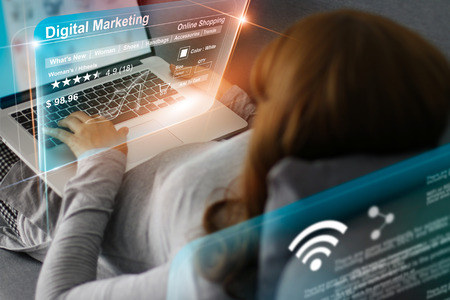 Woman relaxing with hologram modern virtual screen interface online shopping,   and laptop computer networking connection banking payment. Future technology and digital marketing concept.の写真素材