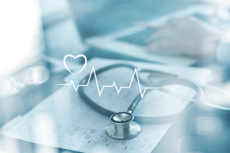 Stethoscope with heart beat report and doctor analyzing checkup on laptop in health medical...