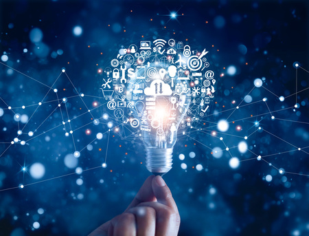Hand holding light bulb and business digital marketing innovation technology icons on network...
