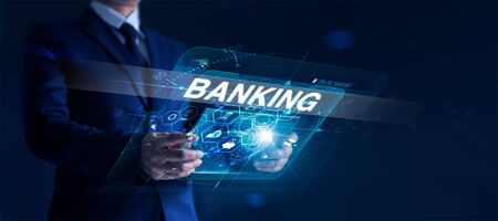 Businessman holding modern interface and word banking in hand with icon network connection on virtual screen dark backgroundの写真素材