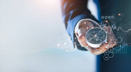 Businessman holding a navigation compass in hand and define marketing direction and analysis growth sale data with search customer global network, Abstract business.の写真素材