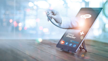Virtual doctor concept, The doctor's hand with stethoscope protrudes from the tablet screen to examine the patient. Online consultation, Virtual hospital and online therapy.の写真素材