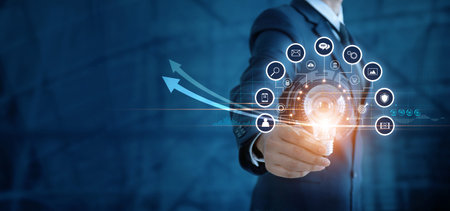 Businessman holding light bulb and analyzing sales data and economic growth graph. Technology and...