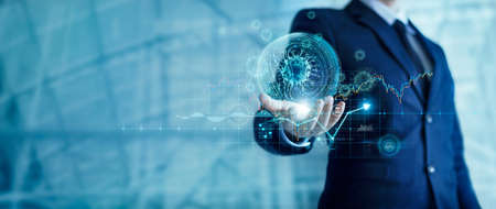 Businessman holding virtual coronavirus globe with stock market chart icons. Covid-19 pandemic...