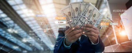 Businessman holding banknote and investment on business global network, and chart currency exchange, stock market diagram, banking, financial and digital marketing, online banking technology.の写真素材