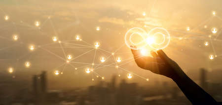 Hands holding sign of infinity on global customer network connection. Digital marketing and unlimited market on  networking.の写真素材