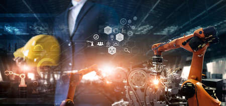 Industry 4.0. Smart industry robot arms control and operation on software by Engineer welding robotics in factory automotive industrial. Industry network connection icon. AI, Artificial Intelligence. Digital manufacturing operation.の写真素材