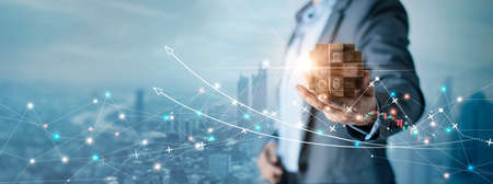 Businessman holding wooden cube with icons of modern business on global network connection concept, Business and economic, Growth and success, Financial and digital marketing.の写真素材