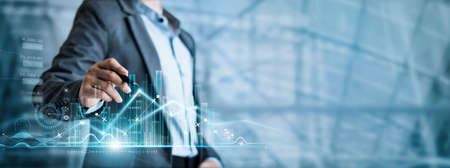 Businessman draw growth graph and progress of business and analyzing financial and investment data, development of success,  business planning and strategy on blue background.の写真素材