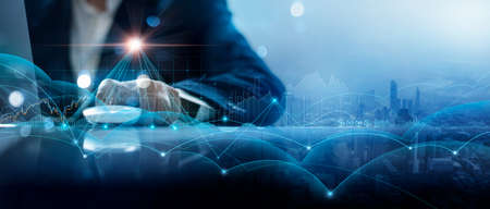 Businessman using laptop and analyzing customer data on economic growth graph chart and management global structure networking with customer data exchanges. Investment and digital marketing network.の写真素材