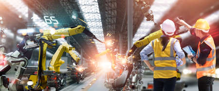 Professional team industrial engineers check, maintenance and control welding robotics automatic arms machine in factory automotive industry with monitoring system software. Industry 4.0の写真素材