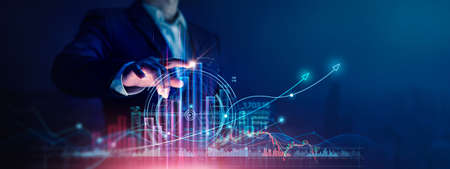 Businessman touch growth graph and progress of business and analyzing financial and investment data ,business planning and strategy on city background.の写真素材