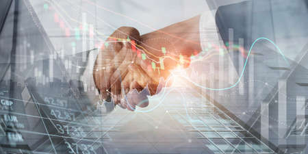 Business handshake for successful of investment deal on business economic growth graph chart on global network, Teamwork and partnership, Global business, Financial, banking and stock market.の写真素材