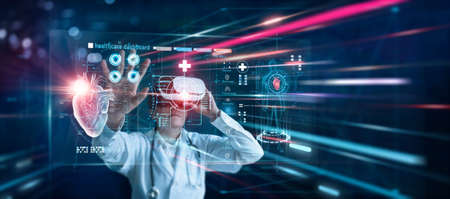 Medical innovation technology concept. Cardiologist doctor wearing virtual reality glasses. Checking heart disease and report testing result with simulator interface, Metaverse. Science and medicineの写真素材