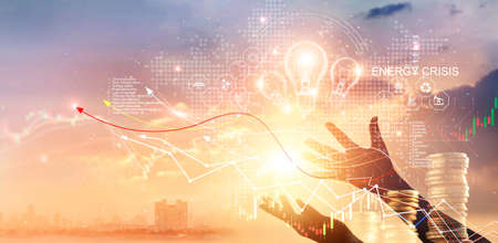 Energy crisis, Hands touch light bulb with energy resources icon and rising graph data chart...