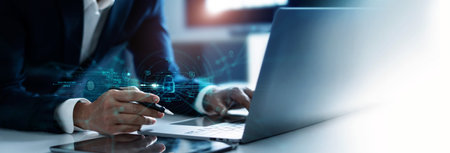 Businessman using laptop and encryption of business data network with fingerprint scanning and Biometric identification of security, Protect business transaction from digital cyber attack.の写真素材