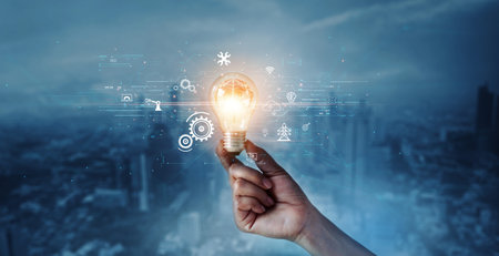 Creative, new ideas and innovation, Hand holding light bulb and smart brain inside and innovation icon network connection on dark blue city background, innovative technology in science and industrial.の写真素材