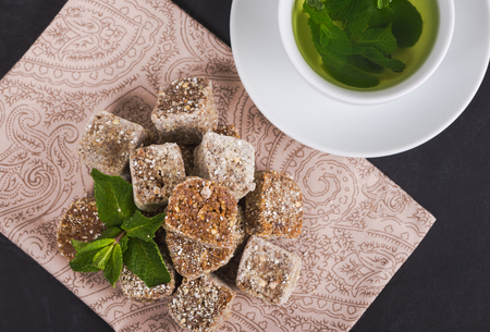 Sweets for raw foodists on a beautiful background with mint tea in a white cup on a white saucerの写真素材