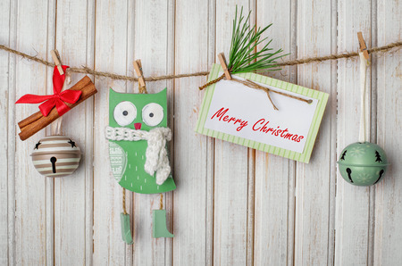 Christmas decorations and toys on a rope with clothespins and tablet for text on wooden backgroundの写真素材
