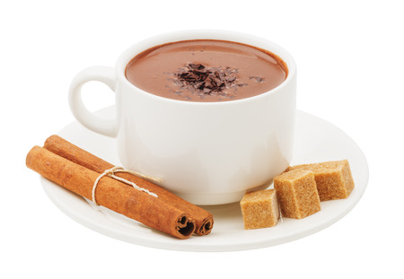 A cup of hot chocolate, cinnamon sticks and cubes of cane sugar on saucer close-up isolated on white backgroundの写真素材