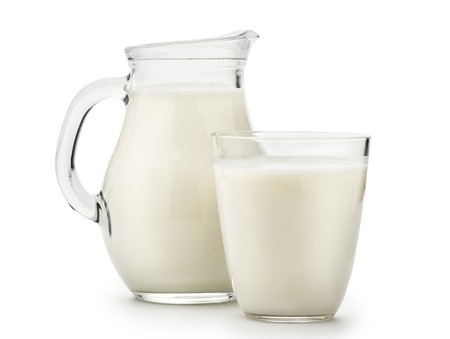 Natural whole milk in a jug and a glass isolated on a white background closeupの写真素材