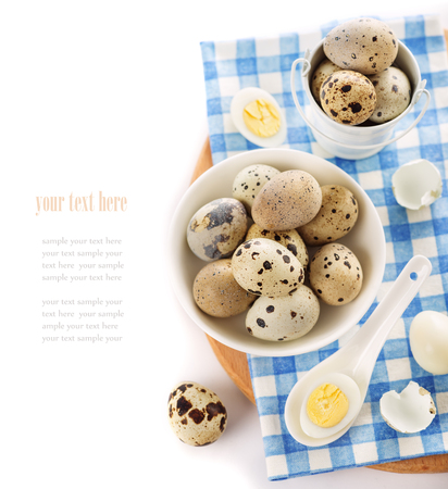 raw and cooked quail eggs in a plate, shell, top view close-up on a white backgroundの写真素材