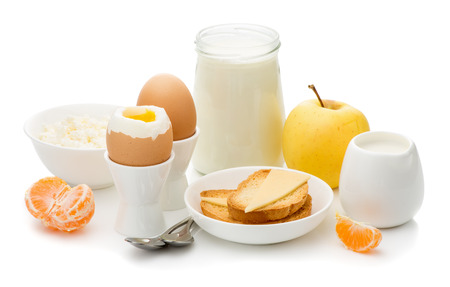 Healthy delicious breakfast, soft boiled eggs in the stands, toast with cheese, cottage cheese, apple, cream, yogurt  on a white background, the concept of a balanced diet, dietの写真素材