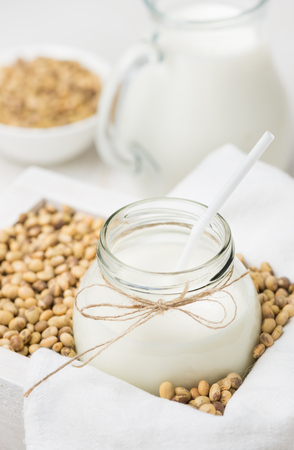 Soy milk in a glass jar and soybeans a cocktail stickの写真素材