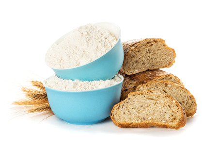 flour in blue plates, sliced bread, ciabatta and wheat ears isolated on white background close upの写真素材