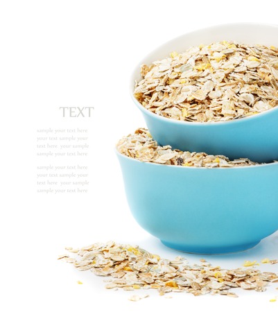 A healthy breakfast, a mixture of cereal flakes, muesli in blue bowls isolated on white backgroundの写真素材