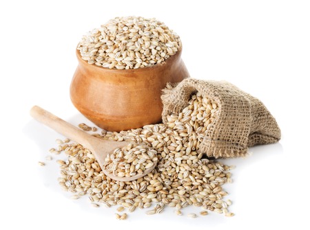 Raw Pearl Barley in bowl and a bag, a wooden spoon isolated on a white background closeupの写真素材