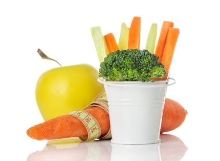 The concept of a healthy eating and lifestyle, vegetables, broccoli, carrots, apple and centimeter isolated on white backgroundの写真素材