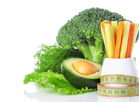 The concept of a healthy eating and weight loss, centimeter, green vegetables, broccoli, carrots and avocado isolated on white backgroundの写真素材
