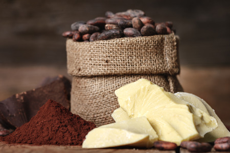 Cocoa butter and ingredients for making chocolate, Cocoa powder in the bowl, cocoa beans on old wooden backgroundの写真素材