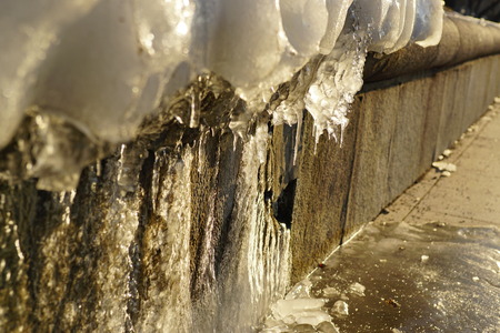 Icicle ice stalactite that forms at the edges of the hanging items, on rocky ledges, and coastal cliffs, wires, tree branchesの写真素材